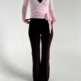 Modelfoto af pige i brune Sania yoga bukser og lyserød Luna wrap bluse. Fra BySofieSønderby