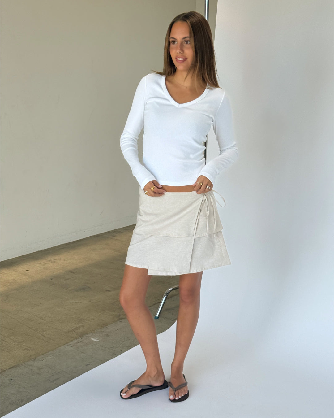 Modelbillede af SINA nederdel, beige og FREYA langærmet v-hals, hvid. Fra BySofieSønderby