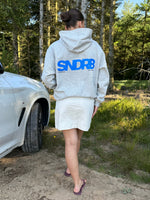 Modelfoto af pige, som bærer SNDRB hoodie, grå og KENDAL nederdel, creme - alt fra BySofieSønderby