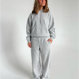 Modelfoto af pige som bærer en Studio Vesterbro hoodie i grå, samt Studio Vesterbro bukser i grå. Alt fra By Sofie Sønderby