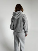 Modelfoto af pige som bærer en Studio Vesterbro hoodie i grå, samt Studio Vesterbro bukser i grå. Alt fra By Sofie Sønderby