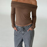 Modelbillede af TARA off shoulder bluse, brun og EDA wide leg jeans, grå. Begge fra BySofieSønderby
