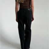 Modelfoto af pige som bærer et par sorte Tokyo jeans, samt iført en brun Thora one shoulder top. Alt fra By Sofie Sønderby