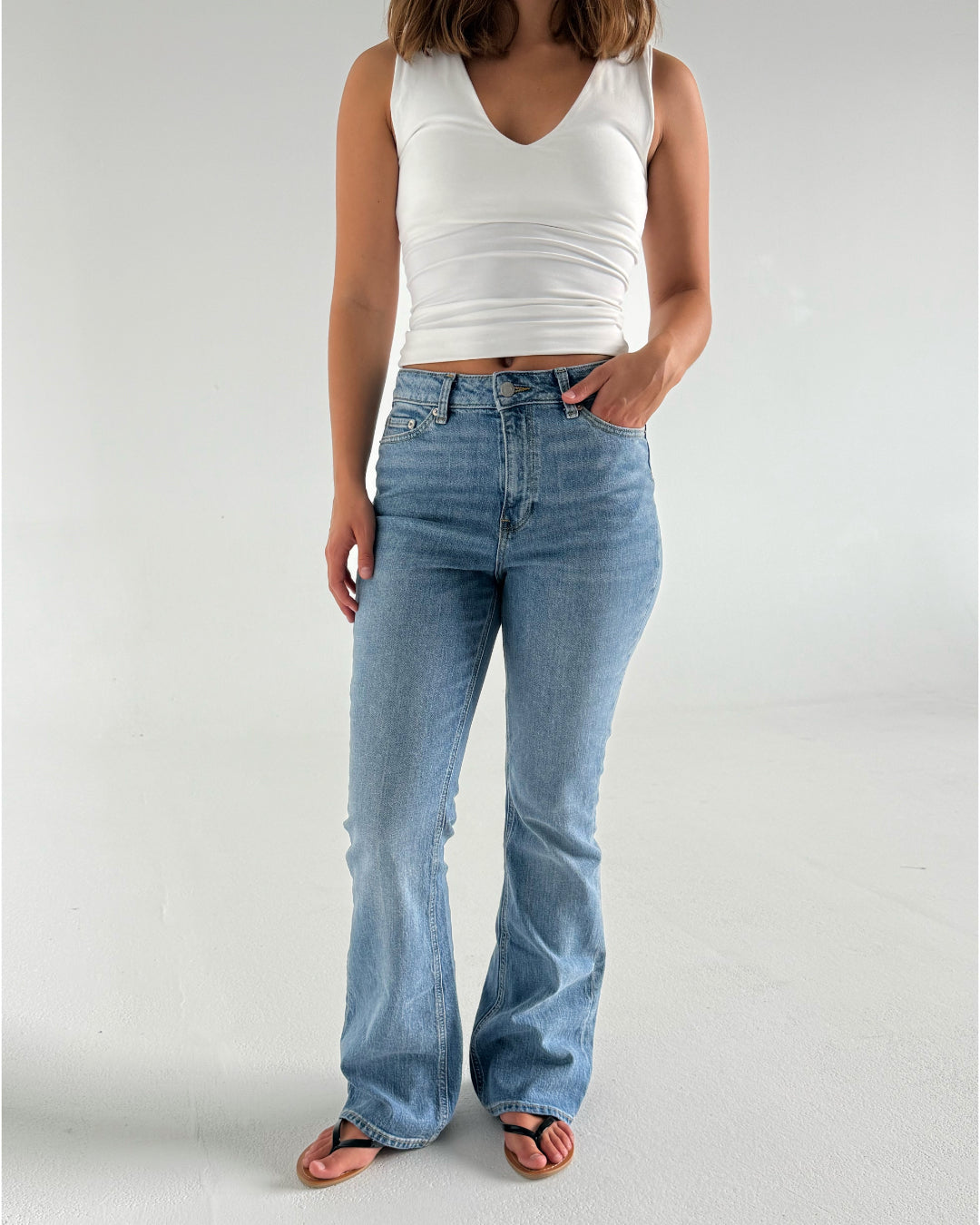 Modelfoto af pige der bærer lyseblå Turin jeans, samt en hvid top. Alt fra BySofieSønderby