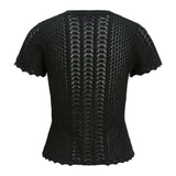 Sort, kortærmet bluse med zigzag-mønster og bølgede kanter, ses fra bagsiden. Stoffet er let gennemsigtigt med forskellige strikmønstre, der skaber tekstur og dybde.